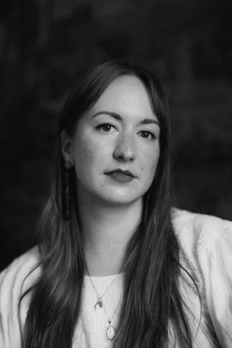 Emily Skillings, black and white photo by Sarah Wagner Miller of a young woman with long hair in a white shirt