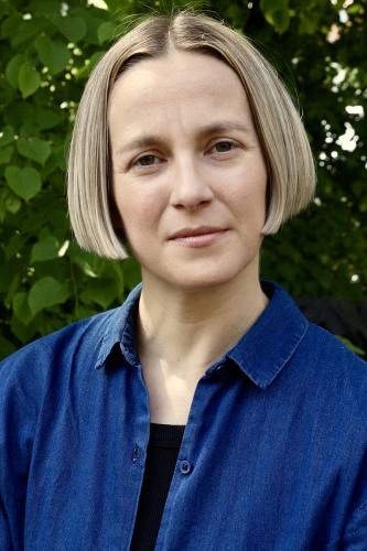 S. Pearl Brilmyer, A woman in a blue shirt with chin length straight blond hair. 