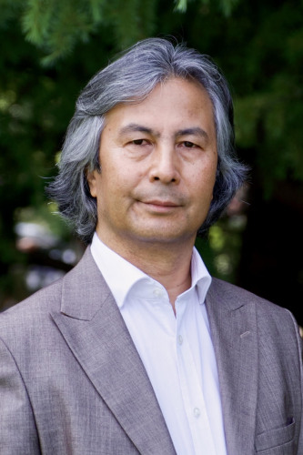 Tahir Izgil, an asian man with medium salt and pepper hair in a white shirt and jacket. Photo credit Asena Izgil