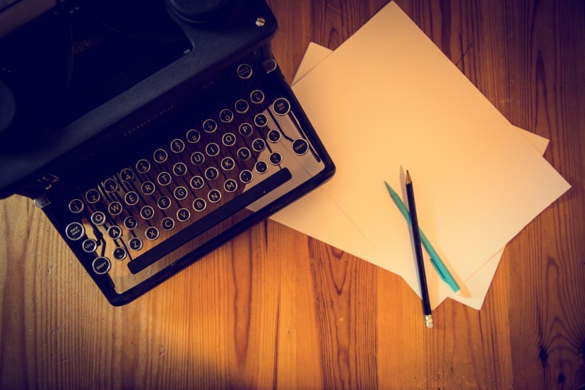 Manual Typewriter, two pencils, and two pieces of paper 
